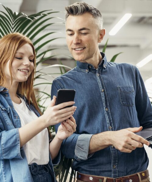 woman-showing-something-phone-her-coworker